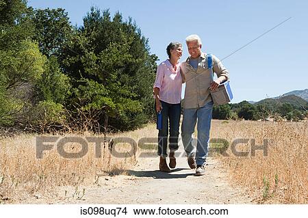 Mature couple walking on rural path View Large Photo Image Picture - Mature couple walking on rural path. Fotosearch