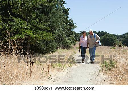 Stock Photography - Mature couple walking on rural path. Fotosearch