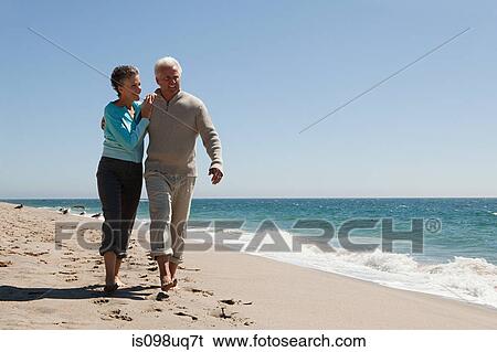 Mature couple walking on the beach View Large Photo Image Stock Photograph - Mature couple walking on the beach. Fotosearch