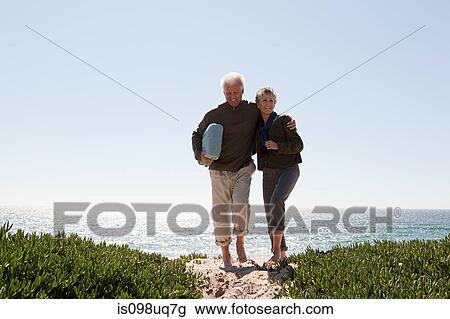 Mature couple walking over dune View Large Photo Image Stock Image - Mature couple walking over dune. Fotosearch