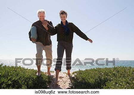 Mature couple walking over dune View Large Photo Image Stock Photo - Mature couple walking over dune. Fotosearch