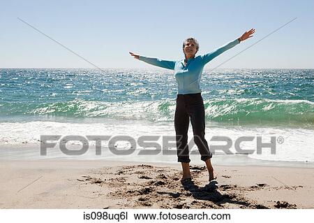 Woman by the sea with arms open View Large Photo Image Stock Image - Woman by the sea with arms open. Fotosearch