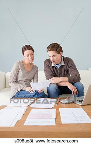 Stock Image - Young couple doing paperwork. Fotosearch