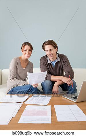 Stock Image - Young couple doing paperwork. Fotosearch