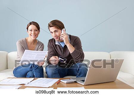 Young couple using computer and doing paperwork View Large Photo Image Stock Photograph - Young couple using computer and doing paperwork. Fotosearch