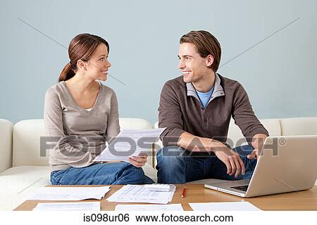 Young couple using computer and doing paperwork View Large Photo Image Stock Photograph - Young couple using computer and doing paperwork. Fotosearch