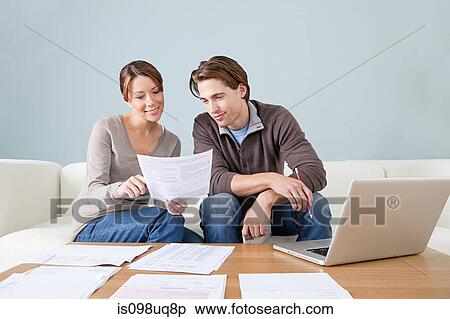Young couple using computer and doing paperwork View Large Photo Image Stock Photography - Young couple using computer and doing paperwork. Fotosearch