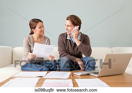 Young couple using computer and doing paperwork View Large Photo Image Stock Photography - Young couple using computer and doing paperwork. Fotosearch