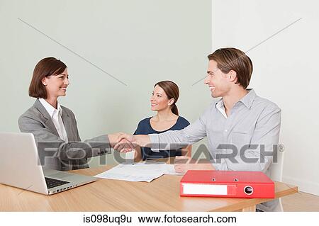 Stock Photograph - Young couple with financial adviser. Fotosearch