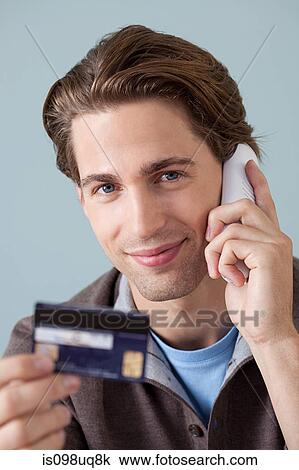 Young man on the phone with credit card View Large Photo Image Stock Image - Young man on the phone with credit card. Fotosearch