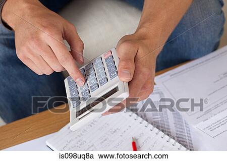 Young man using calculator View Large Photo Image Stock Image - Young man using calculator. Fotosearch