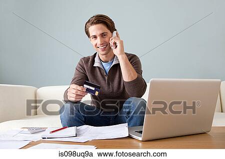 Young man with credit card using laptop View Large Photo Image Stock Image - Young man with credit card using laptop. Fotosearch