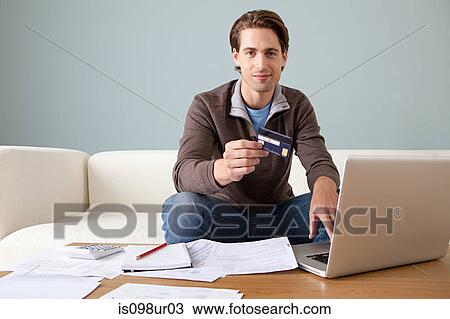 Young man with credit card using laptop View Large Photo Image Stock Image - Young man with credit card using laptop. Fotosearch