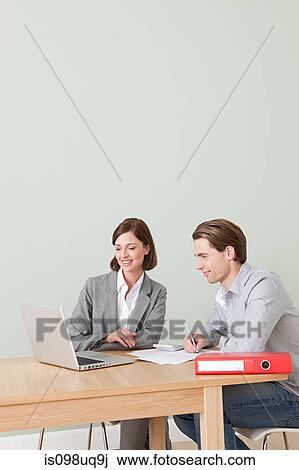 Stock Image - Young man with financial adviser. Fotosearch