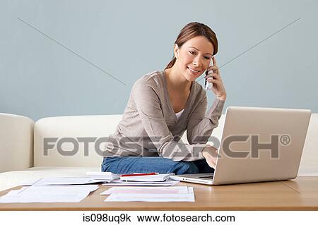 Young woman on the phone with laptop View Large Photo Image Stock Image - Young woman on the phone with laptop. Fotosearch