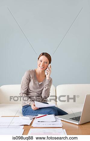 Young woman on the phone with laptop View Large Photo Image Stock Photo - Young woman on the phone with laptop. Fotosearch
