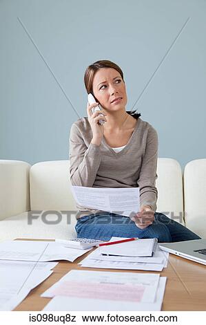 Young woman on the phone with paperwork View Large Photo Image Stock Photo - Young woman on the phone with paperwork. Fotosearch