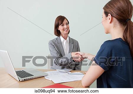 Young woman shaking hands with financial adviser View Large Photo Image Picture - Young woman shaking hands with financial adviser. Fotosearch
