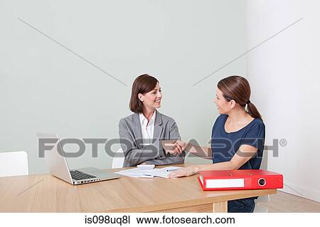 Young woman shaking hands with financial adviser View Large Photo Image Stock Image - Young woman shaking hands with financial adviser. Fotosearch