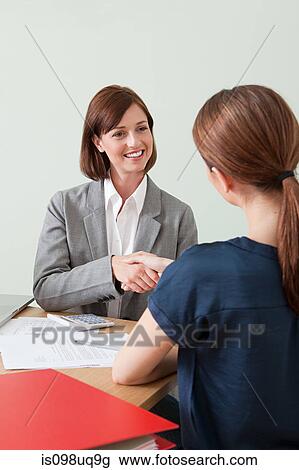 Young woman shaking hands with financial adviser View Large Photo Image Stock Image - Young woman shaking hands with financial adviser. Fotosearch