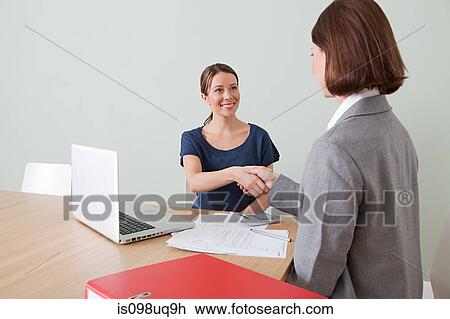 Young woman shaking hands with financial adviser View Large Photo Image Stock Image - Young woman shaking hands with financial adviser. Fotosearch