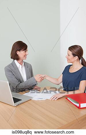 Young woman shaking hands with financial adviser View Large Photo Image Stock Photography - Young woman shaking hands with financial adviser. Fotosearch