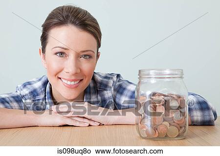 Young woman with jar of coins View Large Photo Image Picture - Young woman with jar of coins. Fotosearch