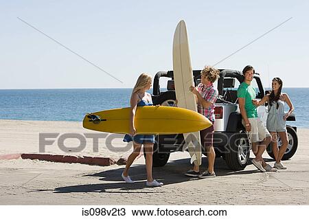 Stock Image - Friends by vehicle with surfboards. Fotosearch