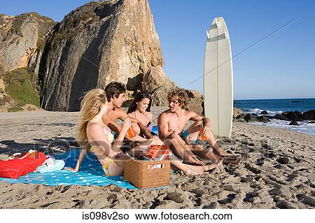 Picture - Friends having a picnic at the beach. Fotosearch