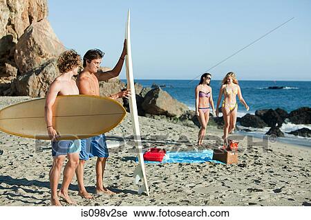 Stock Image - Male surfers at the beach. Fotosearch