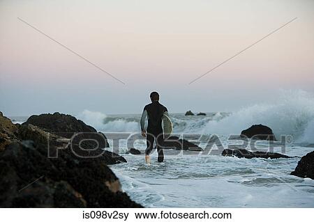 Stock Photo - Surfer standing in the sea. Fotosearch
