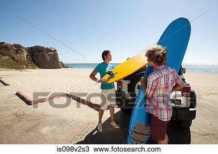 Surfers arriving at the beach View Large Photo Image Stock Image - Surfers arriving at the beach. Fotosearch