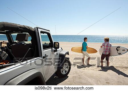 Two young men at the beach with surfboards View Large Photo Image Stock Image - Two young men at the beach with surfboards. Fotosearch