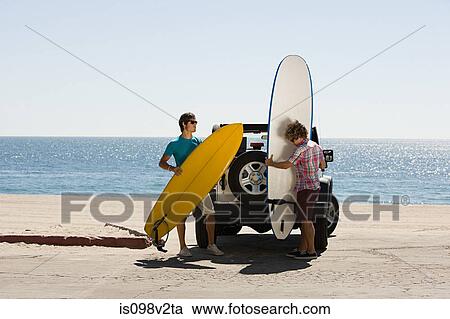 Two young men by SUV with surfboards View Large Photo Image Stock Image - Two young men by SUV with surfboards. Fotosearch
