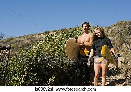 Stock Image - Young couple with surfboards. Fotosearch