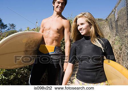 Stock Image - Young couple with surfboards. Fotosearch