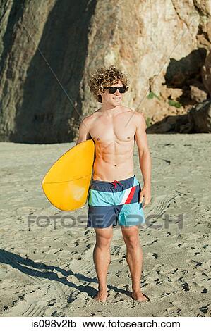 Young man on beach with surfboard View Large Photo Image Stock Image - Young man on beach with surfboard. Fotosearch