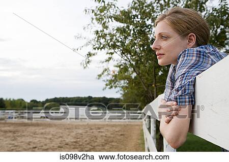 Stock Image - Mid adult woman in paddock. Fotosearch