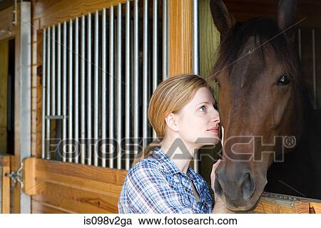Mid adult woman with horse in stable View Large Photo Image Stock Image - Mid adult woman with horse in stable. Fotosearch