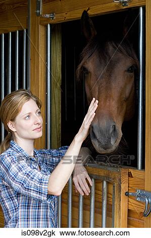 Mid adult woman with horse in stable View Large Photo Image Stock Image - Mid adult woman with horse in stable. Fotosearch