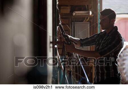 Young man in stable View Large Photo Image Stock Image - Young man in stable. Fotosearch
