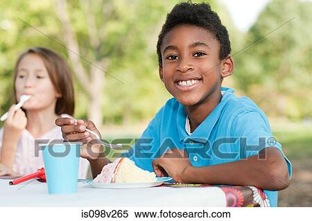 Boy at birthday party eating birthday cake View Large Photo Image Stock Photography - Boy at birthday party eating birthday cake. Fotosearch