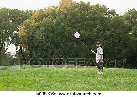 Boy at birthday party holding balloon View Large Photo Image Picture - Boy at birthday party holding balloon. Fotosearch