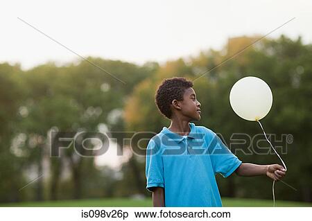 Boy at birthday party holding balloon View Large Photo Image Stock Photography - Boy at birthday party holding balloon. Fotosearch