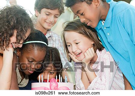 Stock Image - Children at birthday party with birthday cake. Fotosearch