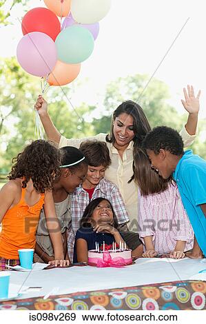 Stock Photo - Children at birthday party with birthday cake. Fotosearch