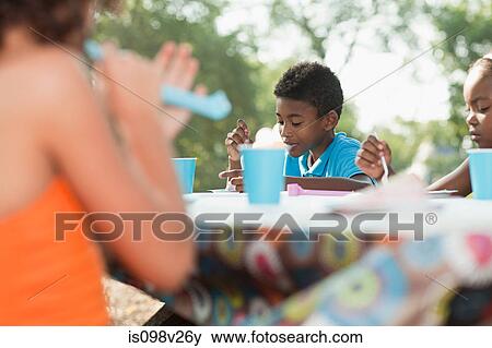 Children sitting at picnic table at birthday party View Large Photo Image Stock Photo - Children sitting at picnic table at birthday party. Fotosearch