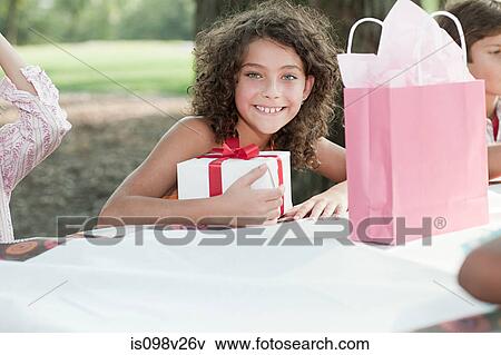 Girl at birthday party with birthday present View Large Photo Image Stock Photo - Girl at birthday party with birthday present. Fotosearch