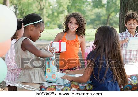 Girl at birthday party with birthday present View Large Photo Image Stock Photo - Girl at birthday party with birthday present. Fotosearch