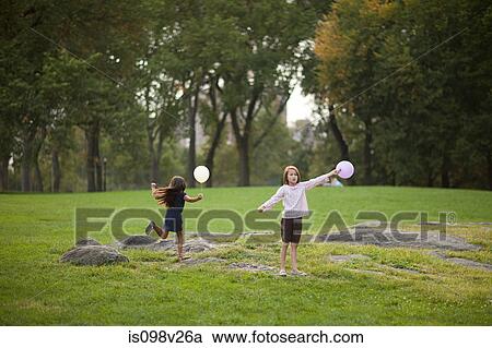 Stock Image - Girls at birthday party holding balloons. Fotosearch